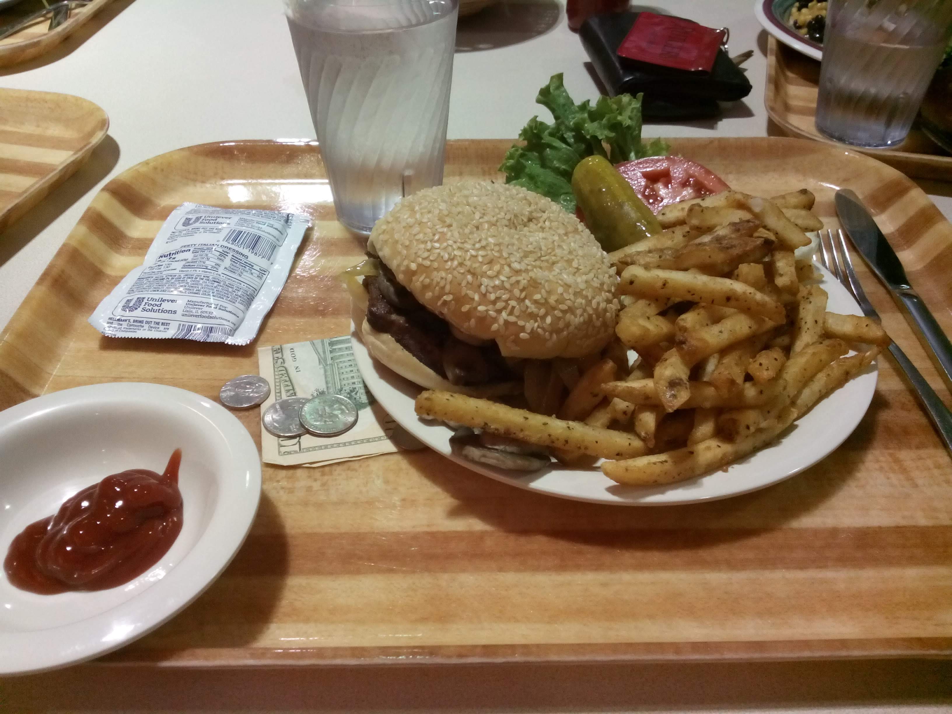 Still life with one burger and few bucks.